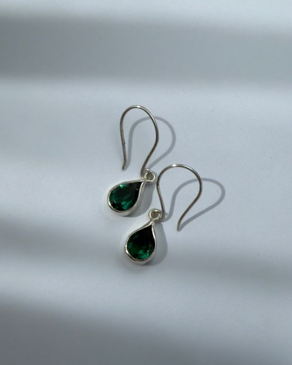 Luma earrings lying in window light
