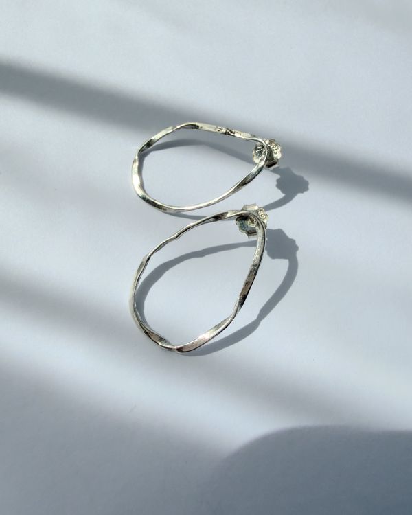 Nirakara earrings: wavy open hoops in sterling silver