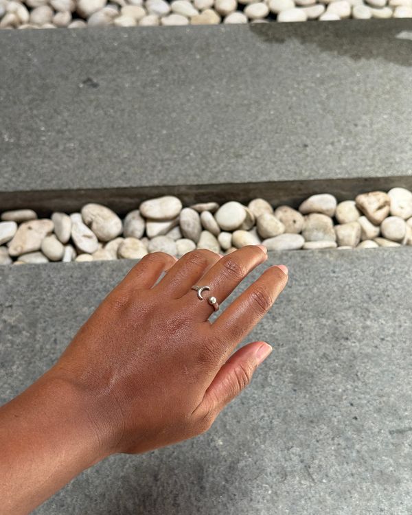 Gerhana ring worn on a hand resting on Balinese stone